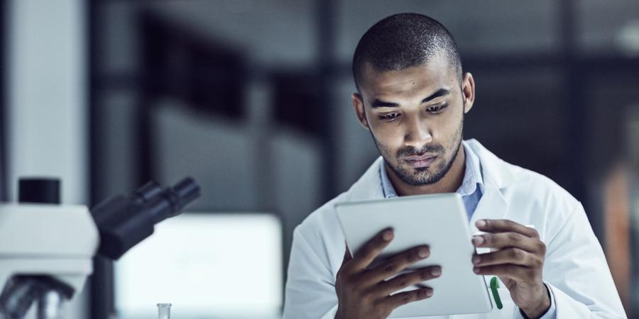 Man in a laboratory looking at a report
